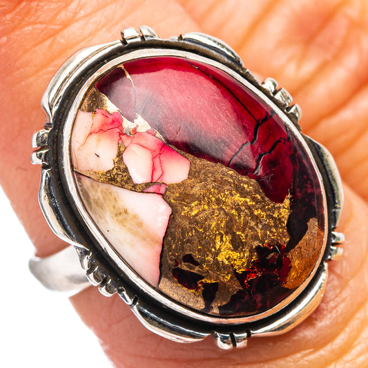 Oval sterling silver ring with bezel-set red, pink, and gold cabochon stone