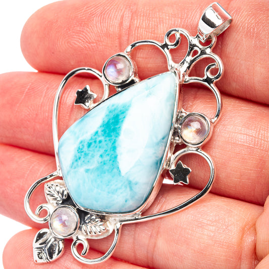 Sterling silver blue teardrop gemstone pendant with round iridescent accents and bail