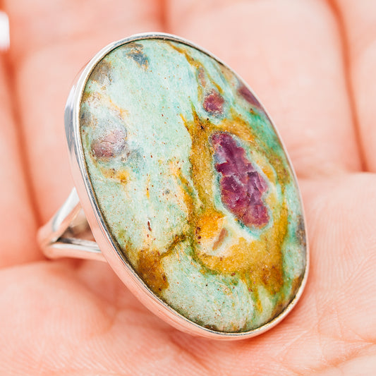 Oval turquoise gemstone ring with purple and yellow speckled pattern, silver band