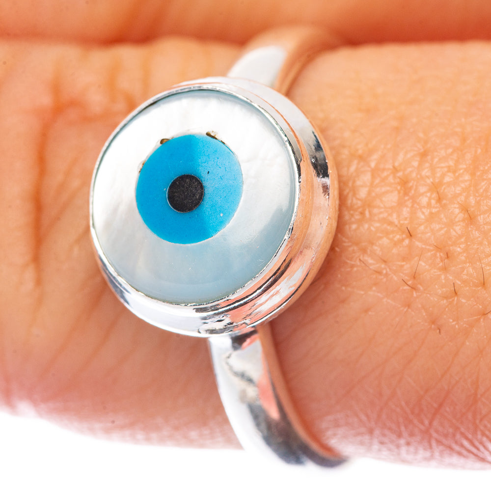 Sterling silver evil-eye ring on finger with blue round eye centerpiece