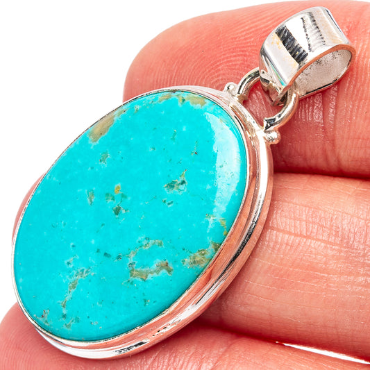 Oval Kingman turquoise pendant with .925 sterling silver bezel and bail, close-up on hand