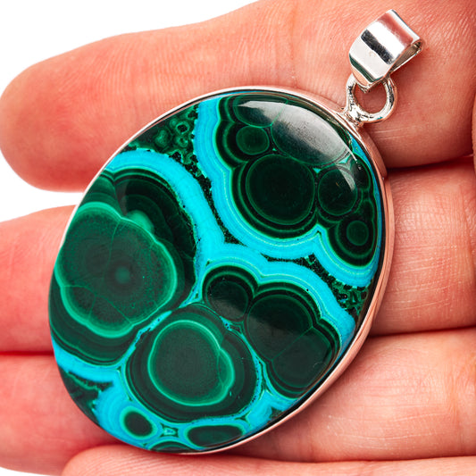 Oval pendant with polished teal/green chrysocolla and malachite stone, silver bail.
