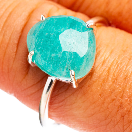 Oval turquoise gemstone ring on finger with three visible silver prongs