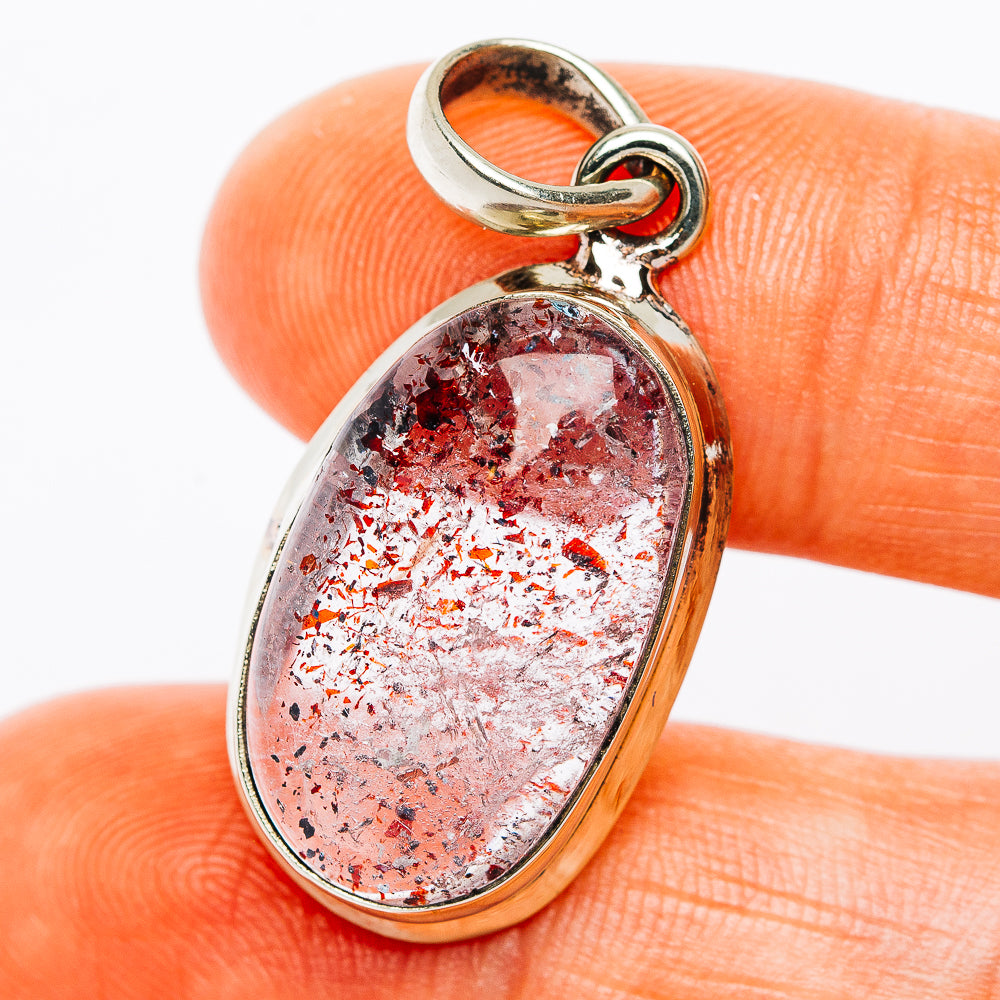 Oval German silver pendant with red and silver lepidocrocite stone, polished bezel.