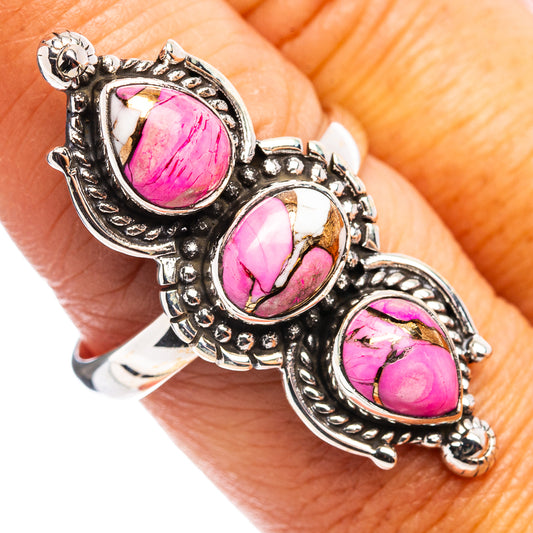 Sterling silver ring on finger with three pink teardrop gemstone settings and scrollwork