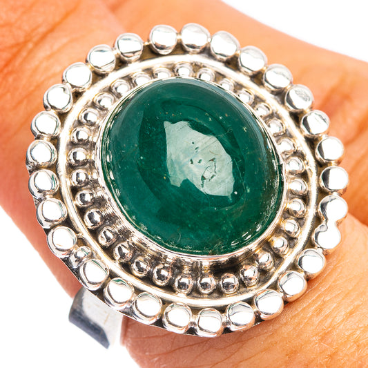 Sterling silver ring with round bezel-set dark green emerald cabochon and halo beads