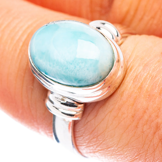 Sterling silver ring with oval blue gemstone, polished band and curled side accents