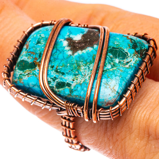 Turquoise gemstone ring with oxidized copper wire and prong bezel, close-up on finger