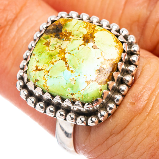 Sterling silver turquoise ring on finger, oval green cabochon with beaded border
