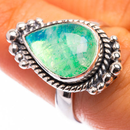 Green moonstone cabochon ring with silver teardrop stone and ornate bezel detailing