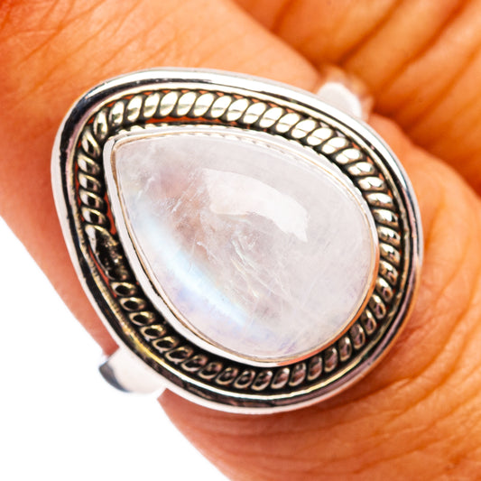 Sterling silver teardrop moonstone ring with ornate bezel and iridescent pale cabochon