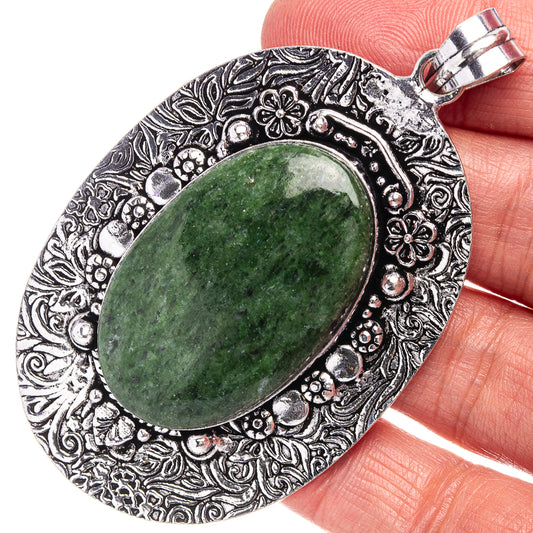German silver serpentine-style pendant with oval green stone and ornate filigree bezel
