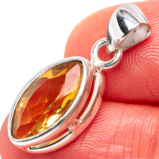Sterling silver oval citrine pendant with faceted gemstone, shown on a finger
