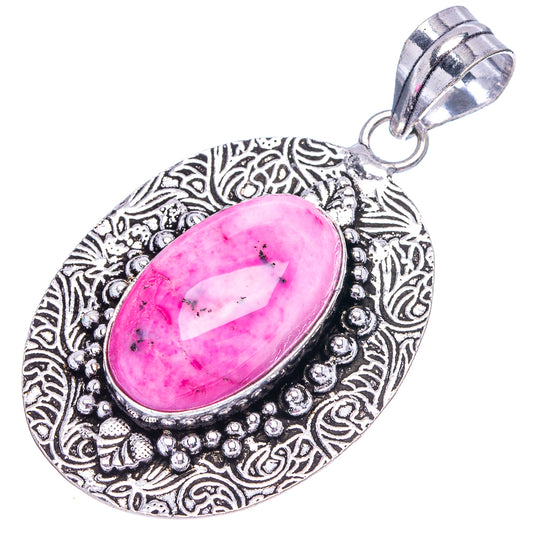 Pink dendritic opal pendant, oval stone set in patterned silver-tone surround with bail