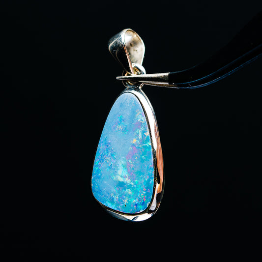 Sterling silver fire opal teardrop pendant with vivid blue opal bezel setting