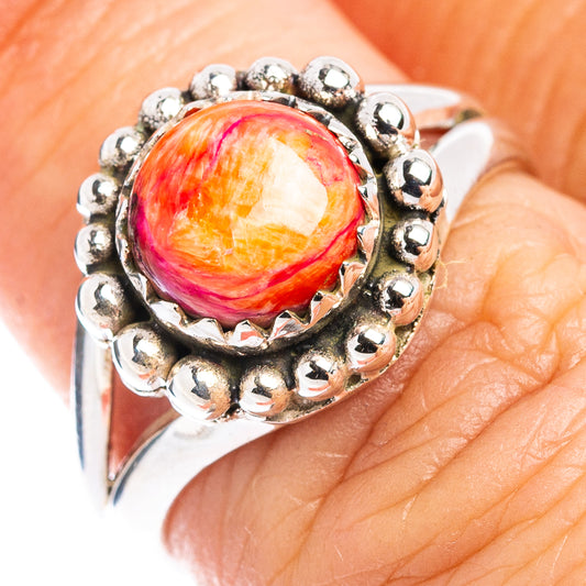 Sterling silver ring featuring orange-red swirl cabochon with raised bead setting