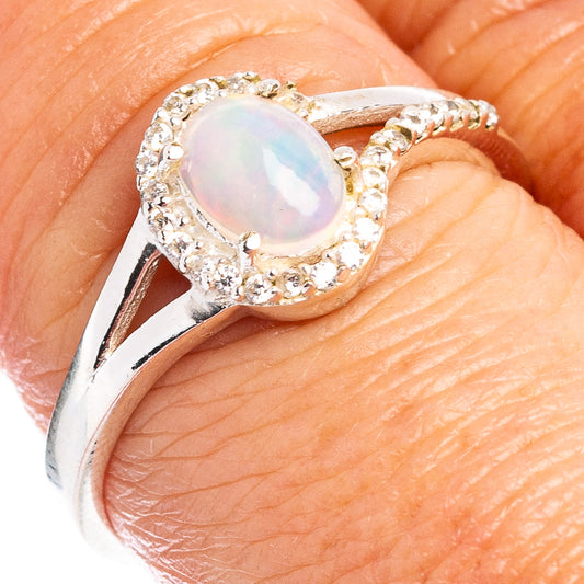 Sterling silver ring with oval opal centerpiece and cubic zirconia halo