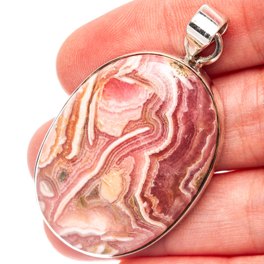 Oval rhodochrosite pendant with swirling pink and cream stone in .925 sterling silver bail