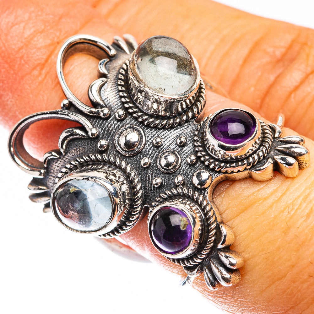 Ornate sterling silver ring with oval light-blue and round purple bezel-set stones.