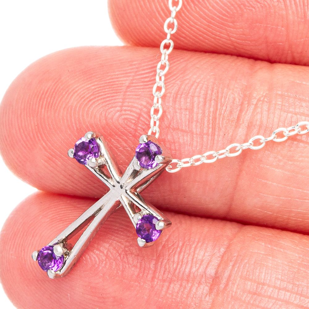 Close-up of sterling silver cross pendant with faceted purple stones and chain link