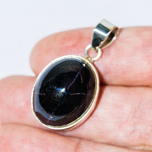 Oval sterling silver garnet pendant with raised bezel setting and top loop bail