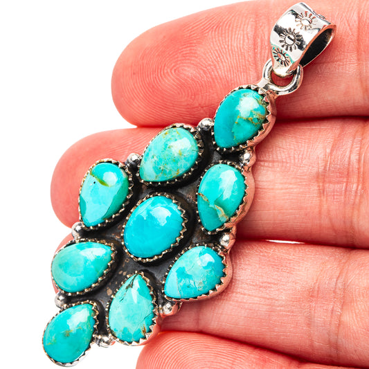 Turquoise teardrop cabochon sterling silver native-style pendant on hand