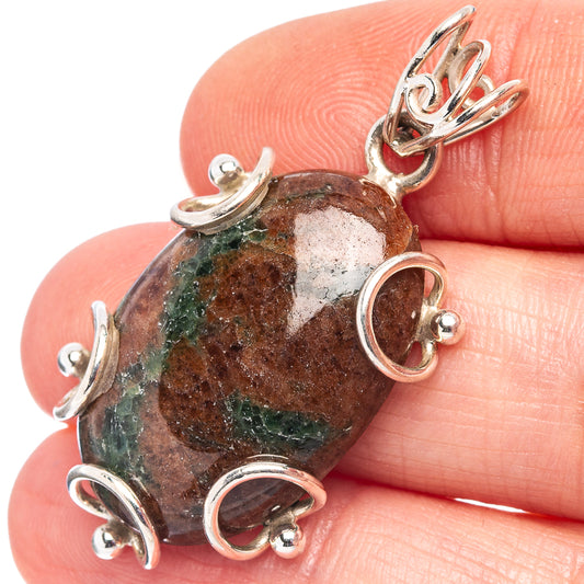 Oval grass garnet pendant close-up, red-and-green stone with sterling silver bezels