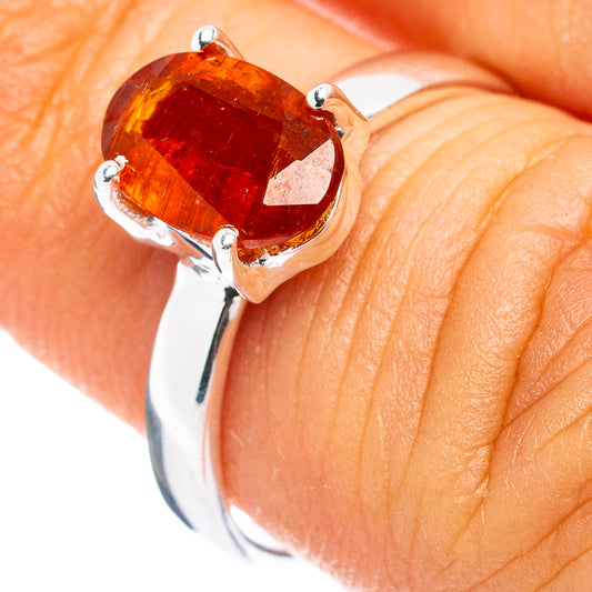 Orange-red faceted kyanite ring in .925 sterling silver, close-up on hand