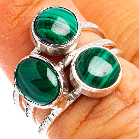Sterling silver malachite ring on finger with three round green stone bezels