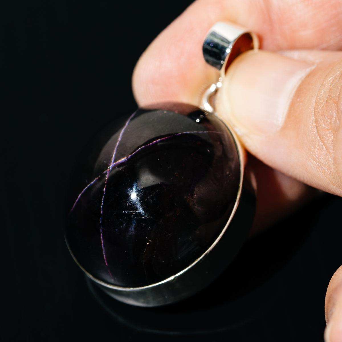 Close-up oval black star garnet pendant with sterling silver loop bail