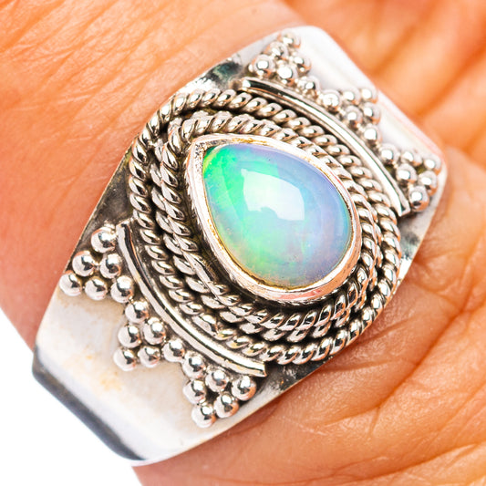 Oval opal ring with ornate sterling silver filigree and iridescent green-blue stone