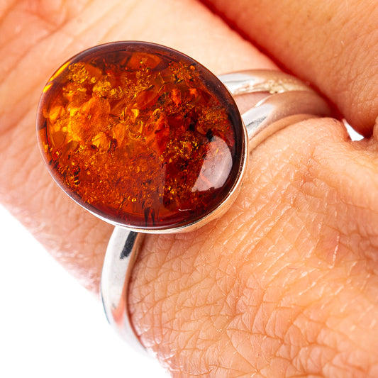 Sterling silver amber ring with round cognac stone, close-up on hand
