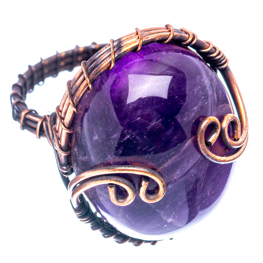 Oxidized copper wire ring featuring purple amethyst cabochon with curled side swirls