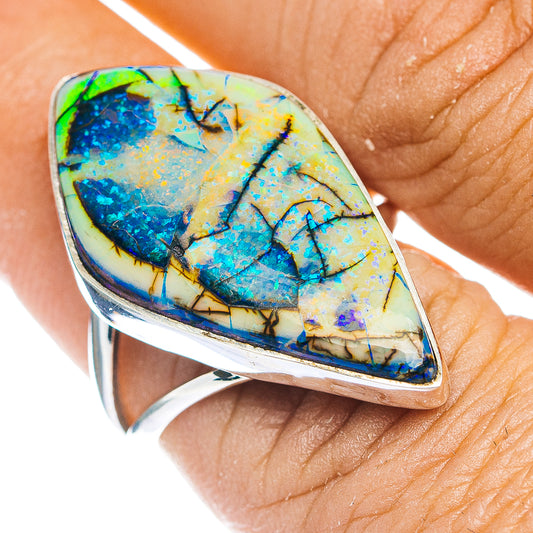 Sterling silver ring with oval opal, blue and yellow flash in a bezel setting.