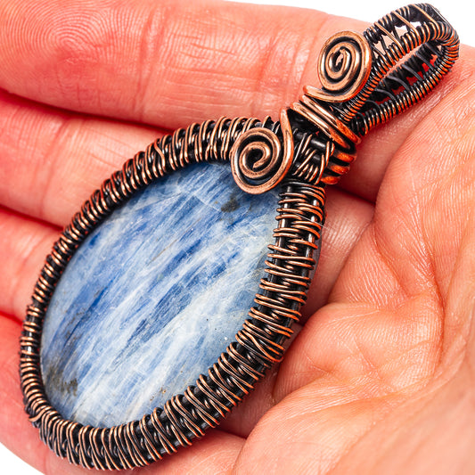 Oxidized copper wire-wrap kyanite pendant with blue teardrop stone, spiral wire details