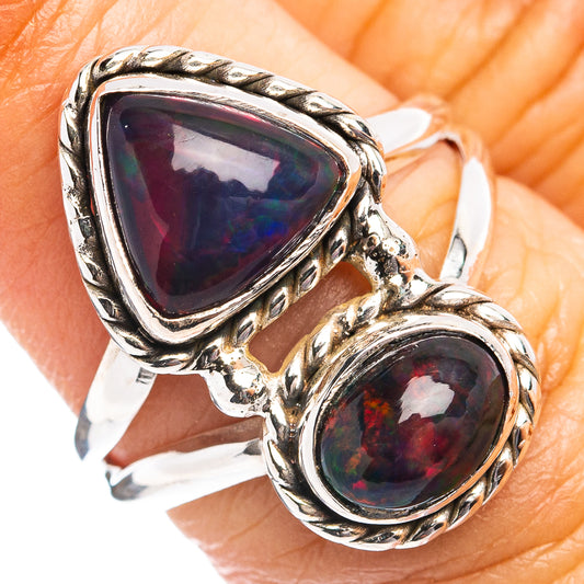 Sterling silver ring with two oval opal stones showing dark red-blue flashes, braided bezel