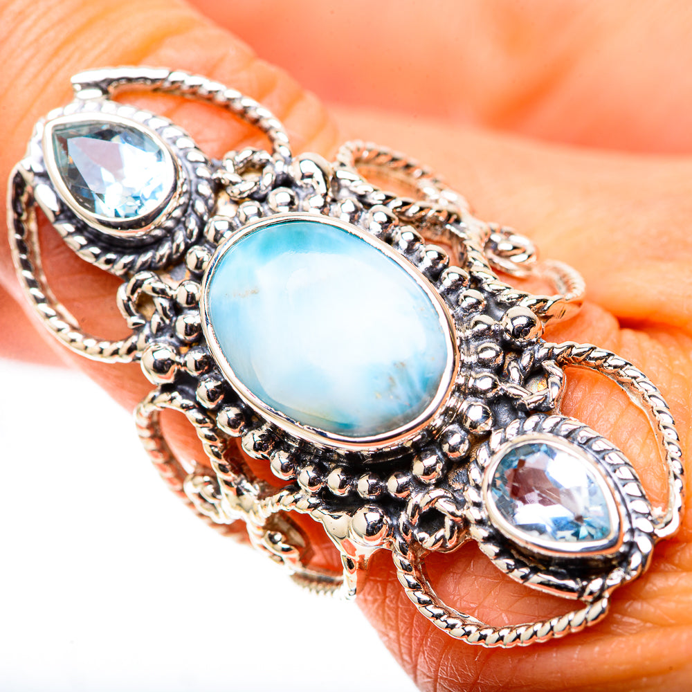 Close-up sterling silver ring with oval opalescent blue center and two blue oval stones