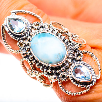Close-up sterling silver ring with oval opalescent blue center and two blue oval stones