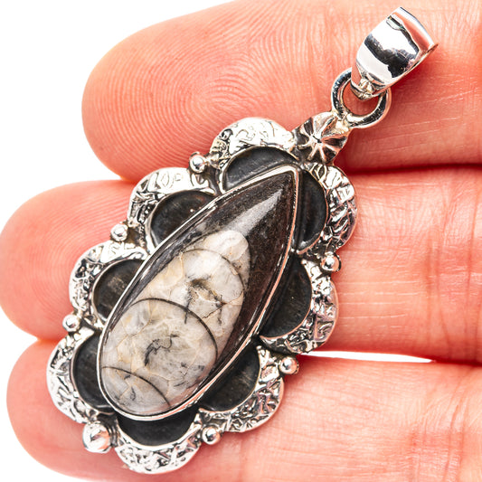 Sterling silver orthoceras fossil pendant with oval black bezel and stone pattern, bail top
