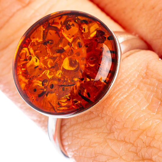 Sterling silver ring with oval Baltic amber cabochon bezel on finger