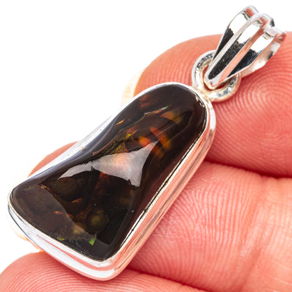 Sterling silver fire agate pendant close-up with dark maroon translucent cabochon and golden highlights