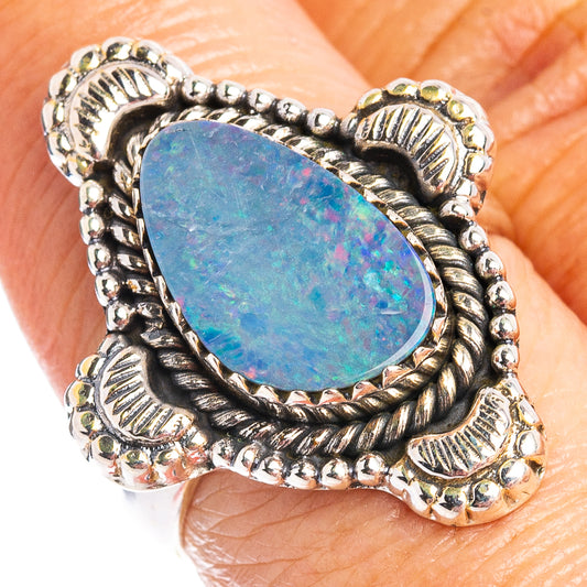 Sterling silver opal ring on finger, large oval blue doublet stone in braided metal frame