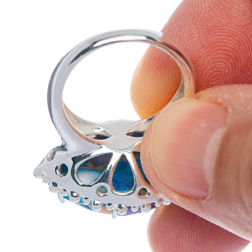 Sterling silver ring side view with prong-like bezel and blue gemstone setting details