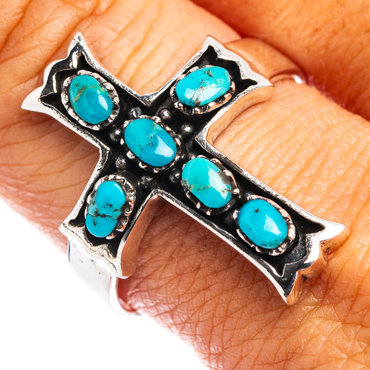 Turquoise cross ring with oval turquoise stones and black metal settings on finger