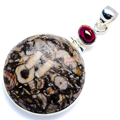 Round fossil stone pendant with silver rim and red garnet top connector