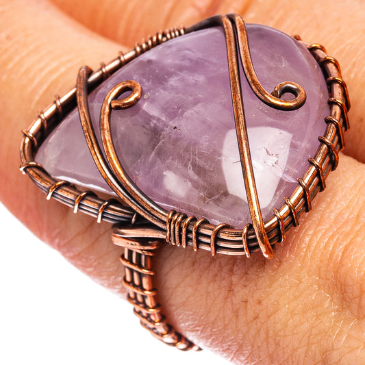 Oxidized copper wire wrap ring with purple teardrop gemstone, on-hand view