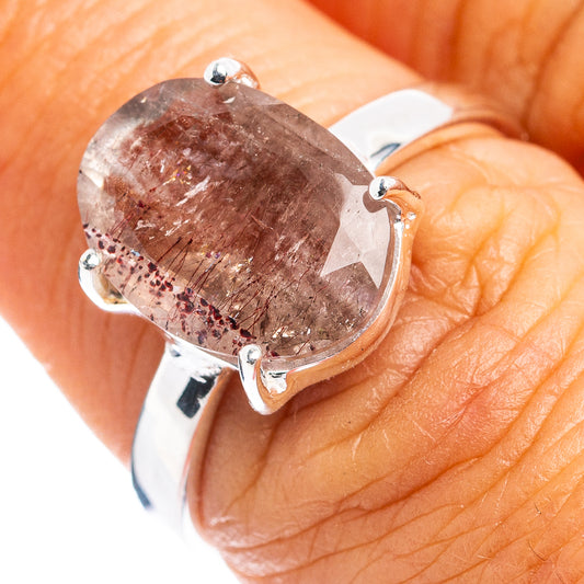 Sterling silver ring with oval pink gemstone and four-prong setting, on finger