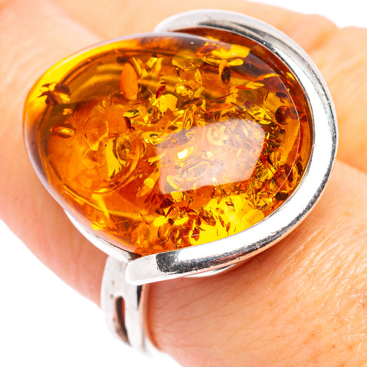 Sterling silver adjustable ring close-up with amber oval cabochon in golden honey color