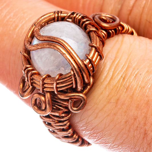 Oxidized copper wire-wrap ring with pale oval moonstone and knotted band loops