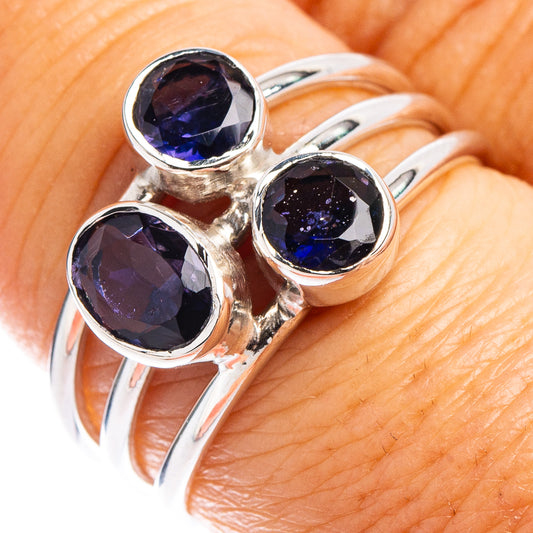 Sterling silver ring featuring three bezel-set round blue-purple gemstones on finger